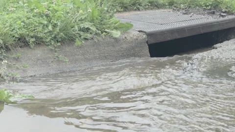 Flooded streets draining into gutter after storm 4k Stock Footage 342372320