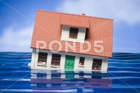 Flooded toy house floating in water Stock Photos