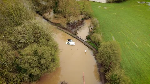 Flooded vehicles sinking in muddy water after heavy rain across United Kingdom Stock Footage 337417848