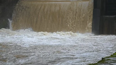 Flooding river flows over small man made hydro plant spillway Stock Footage 144758513