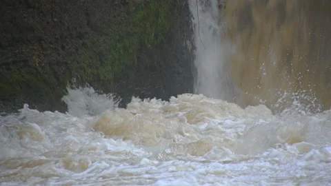 Flooding river flows over small man made hydro plant spillway Stock Footage 144758626