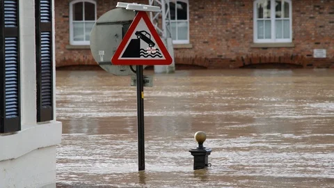 Flooding by submerged roadsign warning of quayside ahead york uk Stock Footage
