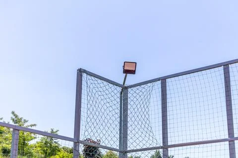 Floodlight Lamp Mounted on High Metallic Sports Court Fence Stock Photos