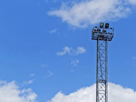 Floodlight Tower Against Blue Sky and White Clouds with Copy Space Stock Photos