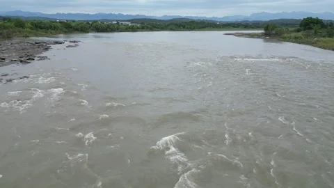 Floods flow down from downstream, wide river is filled with floodwater. Stock Footage 321468175