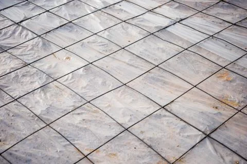 Floor area covered in a sheet of plastic and a mesh of steel reinforcing rods Stock-Fotos