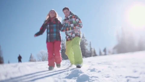 Floor level shooting of joyful young people sliding in the snow towards camera Video stock 71782049