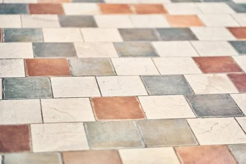 The floor is lined with vintage, geometric patchwork tiles. Texture of stone 库存照片