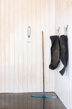 Floor squeegee and rubber car mats hanging on wall in car wash Stock Photos