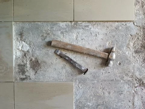 Floor tile removal. Old tools on floor. Dismantling old floor tiles. Renovations Stock Photos