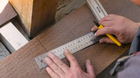 Flooring installation a terrace. Carpenter draws a cutting line on wood plank Stock Footage 155691315