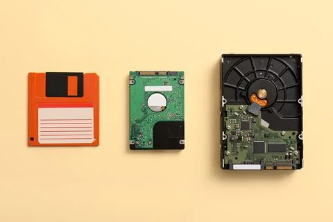 Floppy disk and hard drives on beige background Stock Photos
