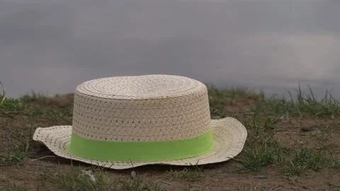 Floppy straw hat left by water side Video stock 153513497
