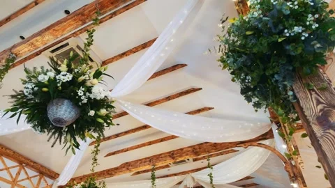 Floral arrangements hanging from ceiling in rustic event venue Video stock 342134235