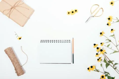 Floral flat lay composition with empty sketchbook Stock Photos