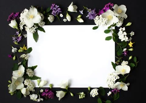 Floral frame made of different spring flowers on black background. Flawers flat Stock Photos