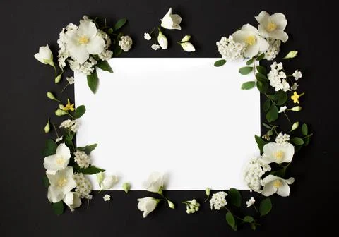 Floral frame made of different spring flowers on black background. Flowers flat Stock Photos