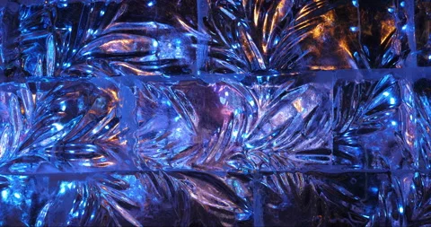 Floral pattern carved on ice wall illuminated on dark evening Stock Footage 256259288