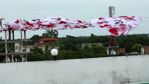 A floral-printed white bed sheet and pillowcases hanging on a clothesline Stock Footage 317867844