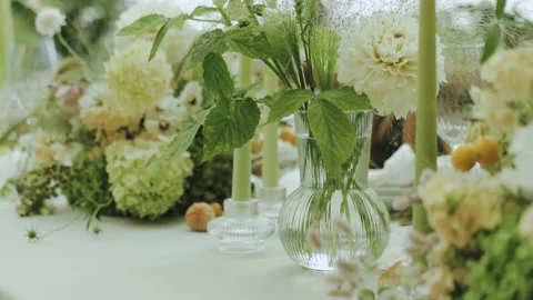 Floral table setting complemented by soft candles and lush greenery. Wedding Stock Footage 306521105