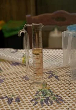 A Florentine glass separator with a layer of essential oil. Stock Photos