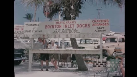 FLORIDA - 1962 - A couple pose behind the dock's wooden sign. Passengers board a Stock Footage 328179072