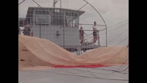 FLORIDA - 1978 - Crewmen setting up parachute equipment on deck as a female NASA Video stock 328179545