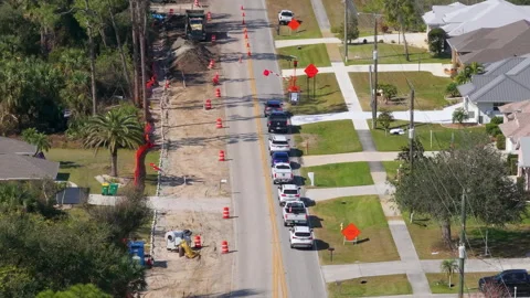 Florida residential road under construction with excavators, cones, and warning Stock Footage 325352730