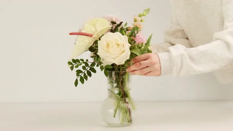 Florist adding new flower to bouquet in a vase, creating composition. Stock Footage 170658210