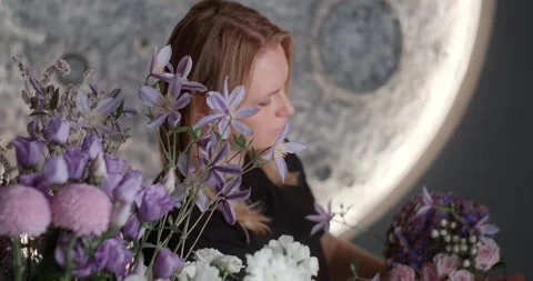The florist assembles an arrangement of flowers for a customer in her store Video stock 250385129