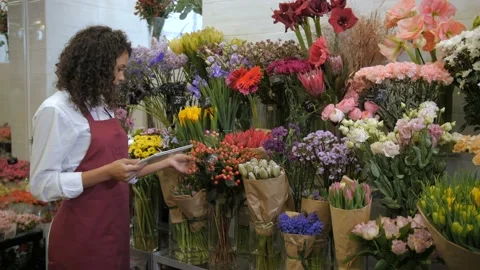Florist checking prices with tablet in flower shop Stock Footage 107569898