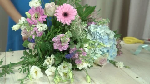 Florist composes the composition in a hat box, inserts pistachio sprigs into an  Stock Footage 80359923