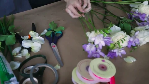 Florist concept. Close up florist makes bouquet on craft table. Work in progress Stock Footage 83345207