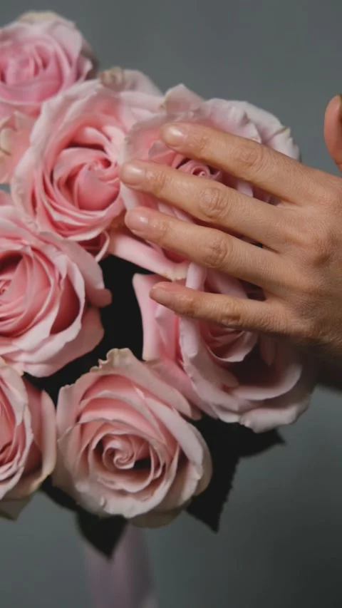 A florist creates a custom bouquet. Close-up of a bouquet of roses against a Stock Footage 319051148