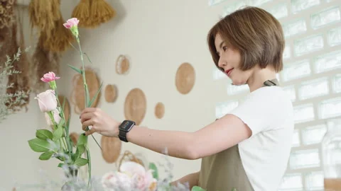 Florist in a creative workshop arranging fresh flowers Stock Footage 272214091