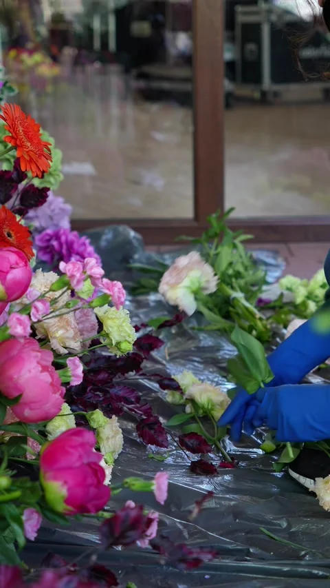 Florist cuts and inserts carnations into a romantic wedding colorful flower arra Stock Footage 318558126