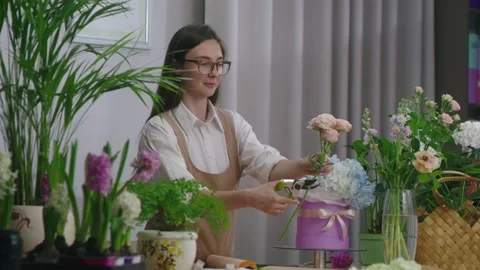 Florist cuts a flower to create a beautiful arrangement of flowers in a box Stock Footage 195932553