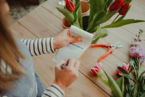 Florist in flower shop making note on order pad, elevated view Stock Photos