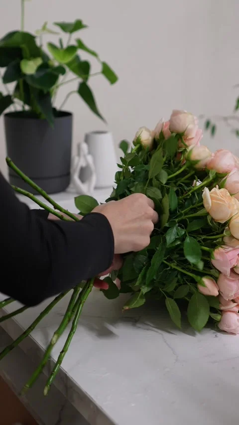 Florist forms a bouquet on the table from pink bush rose Christie Stock Footage 317961805