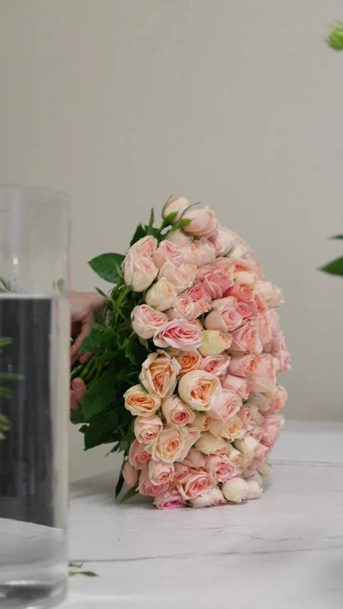 Florist forms a bouquet on the table from pink bush rose Christie Stock Footage 317961821