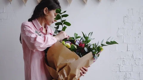 Florist inserts a branch of greenery in a large modern bouquet Stock Footage 86888503