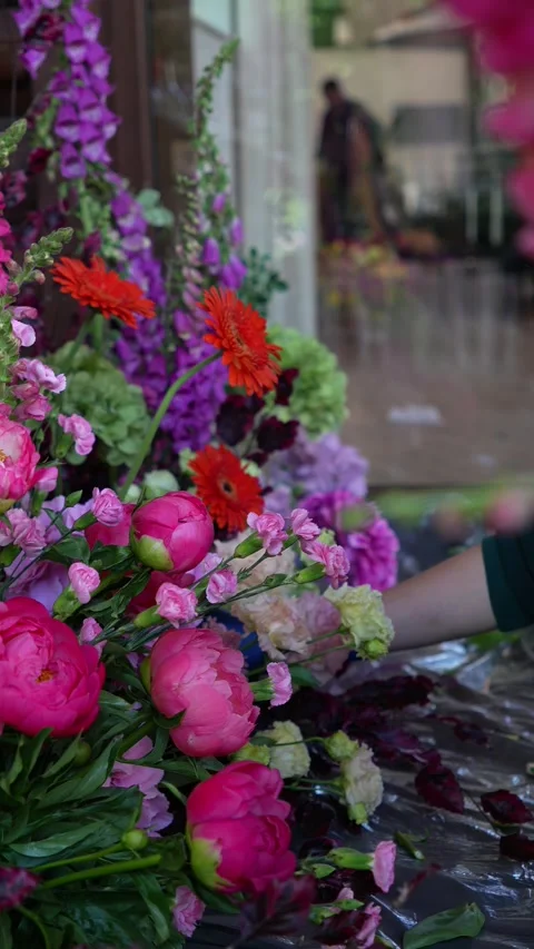 Florist inserts a carnation into a romantic wedding colorful flower arrangement. Stock Footage 318558111