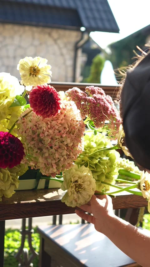 Florist inserts a flower into a wedding flower arrangement in an ekibana for the Stock Footage 318922174