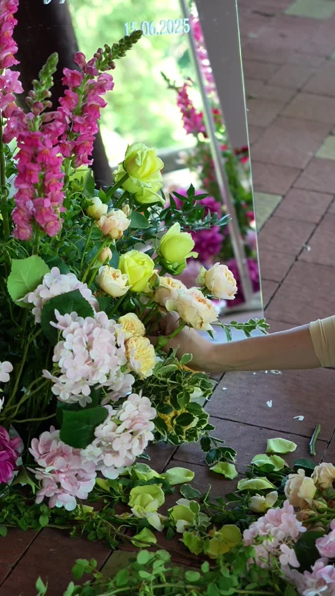Florist inserts a rose into a romantic wedding colorful flower arrangement near Stock Footage 318558108