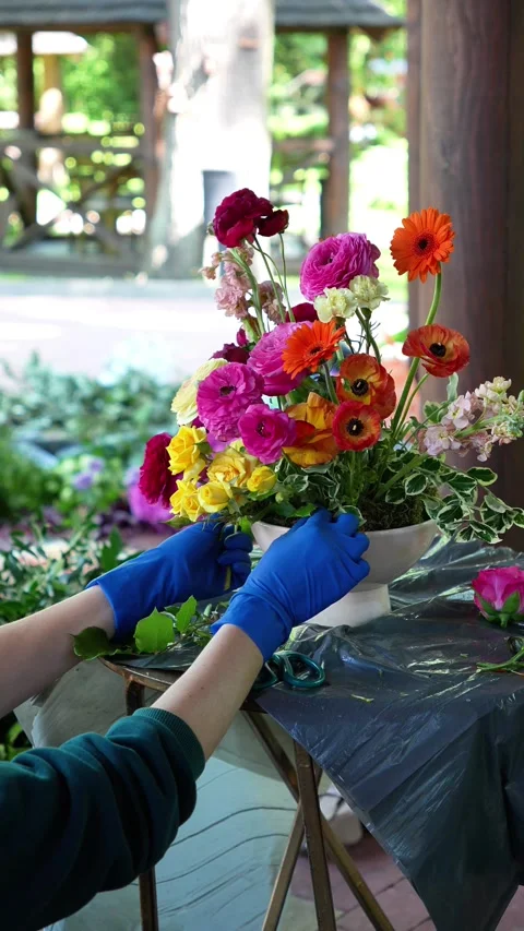 Florist inserts yellow spray rose into colorful wedding ekibana in vase. Wedding Stock Footage 318558120