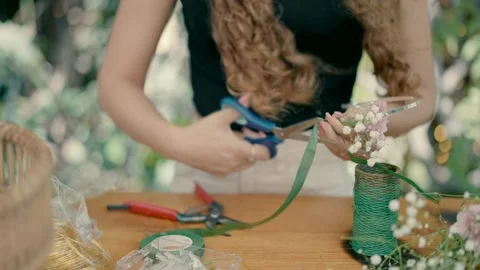A florist makes a bow for the head with flowers Stock Footage 220625543