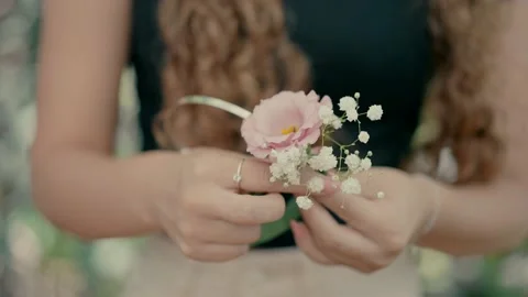 A florist makes a bow for the head with flowers Stock Footage 220625567