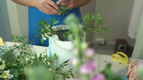 Florist for making a beautiful hat box with flowers close-up 4k. Stock Footage 80359530