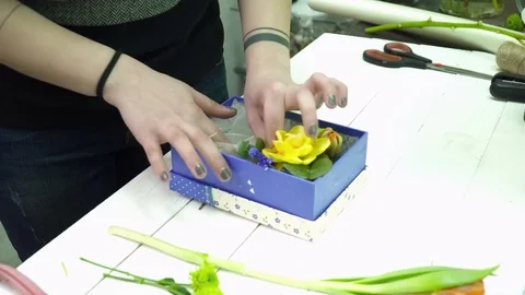 Florist making a bouquet in the box on the table Video stock 74713952