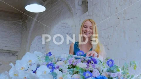Florist making large floral basket with flowers at flower shop Stock Photos